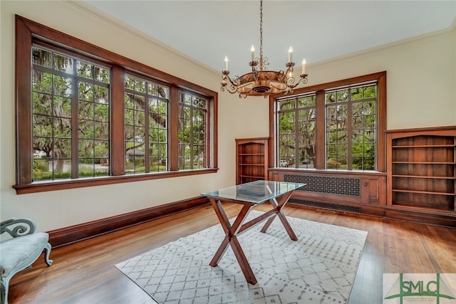 office area with a chandelier, radiator, wood finished floors, and ornamental molding