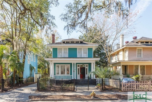 american foursquare style home featuring a gate, a porch, a chimney, concrete driveway, and a fenced front yard