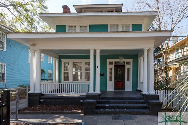 view of front of home featuring a porch, a chimney, and fence