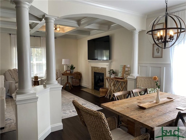 dining area with beamed ceiling, ornamental molding, coffered ceiling, dark wood finished floors, and a high end fireplace