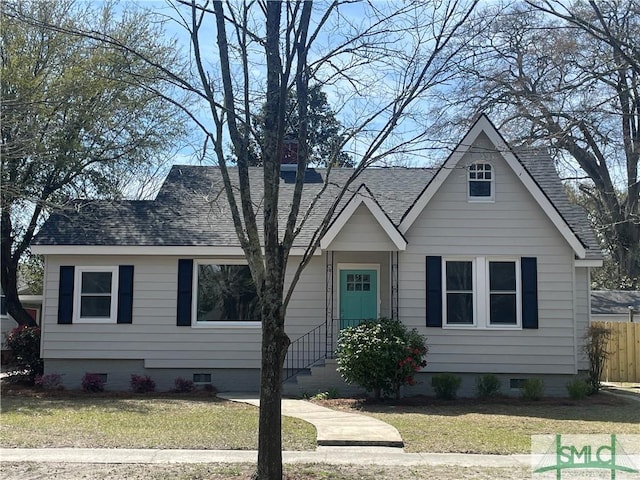 view of front of house with a front yard, fence, roof with shingles, and crawl space