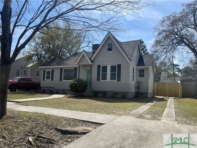 view of front of property with a front lawn, fence, a shingled roof, crawl space, and a chimney