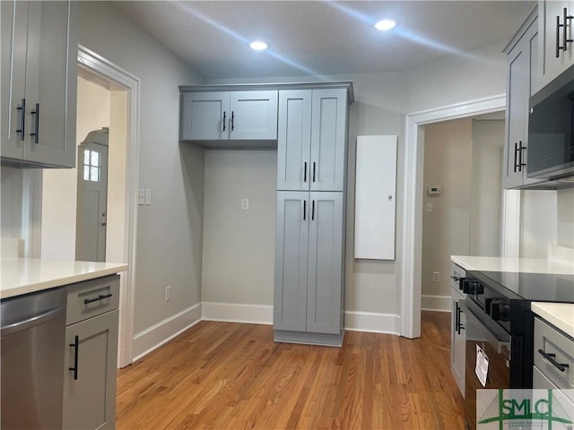 kitchen with light wood-style flooring, appliances with stainless steel finishes, and light countertops