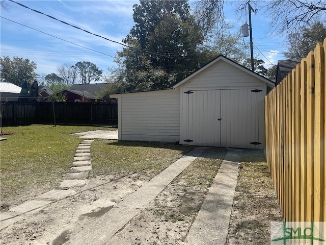 view of shed with concrete driveway and a fenced backyard