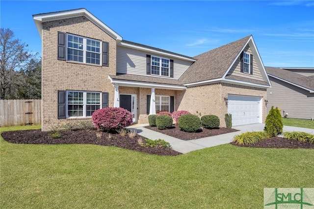 traditional-style home featuring brick siding, an attached garage, a front yard, and fence