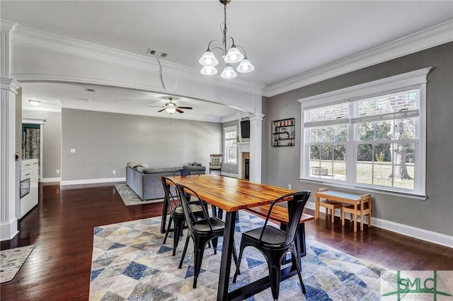 dining area with a ceiling fan, visible vents, decorative columns, dark wood-style flooring, and crown molding