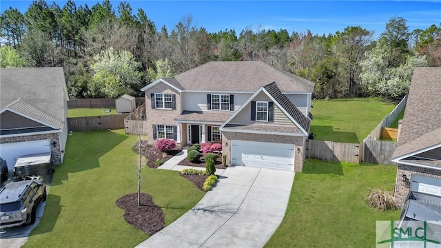 traditional-style house with concrete driveway, fence, and a front lawn