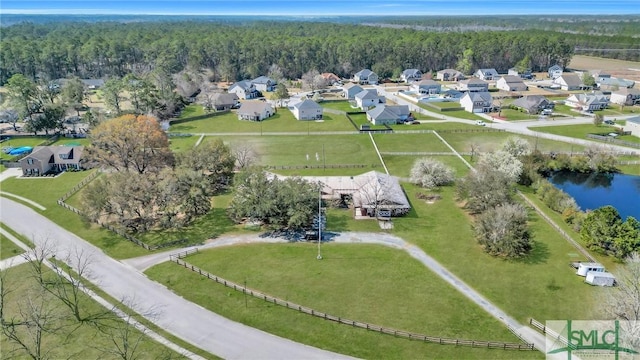 bird's eye view featuring a view of trees, a residential view, and a water view