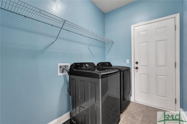 laundry room with laundry area, baseboards, tile patterned floors, and washing machine and clothes dryer