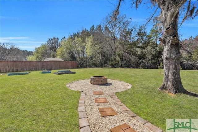 view of yard with a fire pit and fence