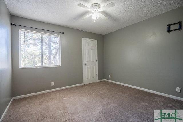 unfurnished room featuring carpet flooring, baseboards, a textured ceiling, and a ceiling fan