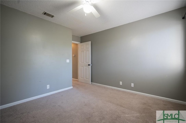 spare room with visible vents, a ceiling fan, a textured ceiling, carpet, and baseboards