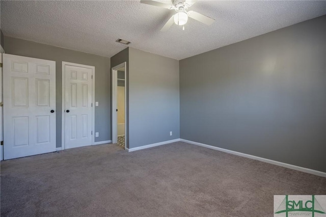 unfurnished bedroom featuring carpet flooring, baseboards, visible vents, and a textured ceiling