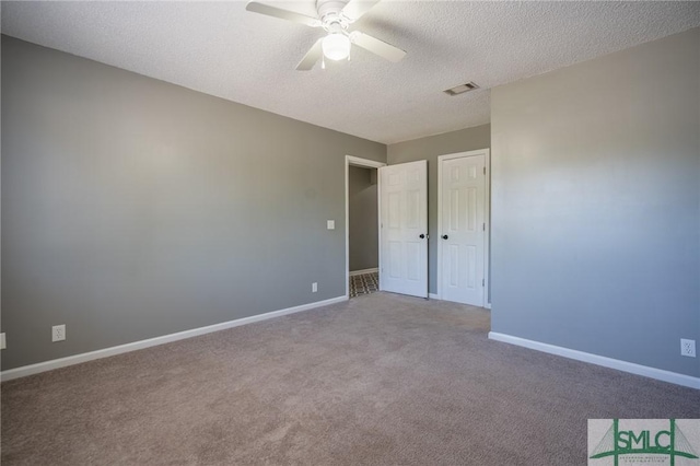 unfurnished bedroom featuring visible vents, baseboards, ceiling fan, carpet flooring, and a textured ceiling