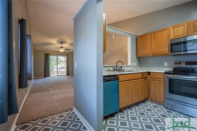 kitchen featuring a ceiling fan, carpet floors, a sink, light countertops, and appliances with stainless steel finishes