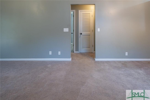 spare room featuring baseboards and carpet