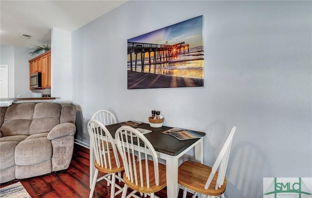 dining space with visible vents and wood finished floors