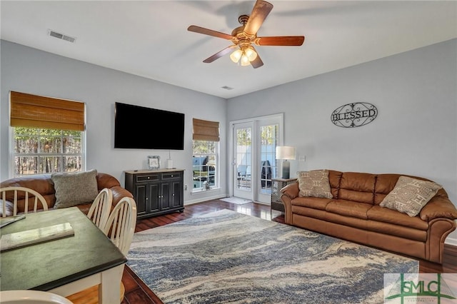 living room featuring dark wood finished floors, a ceiling fan, and visible vents