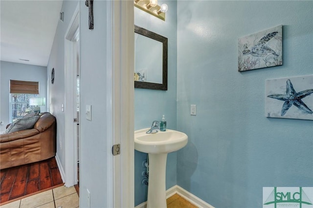 bathroom featuring a sink, baseboards, and tile patterned flooring