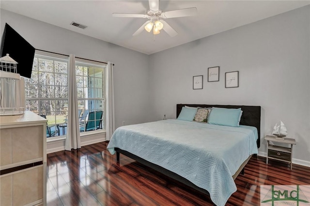 bedroom with visible vents, baseboards, wood finished floors, and a ceiling fan