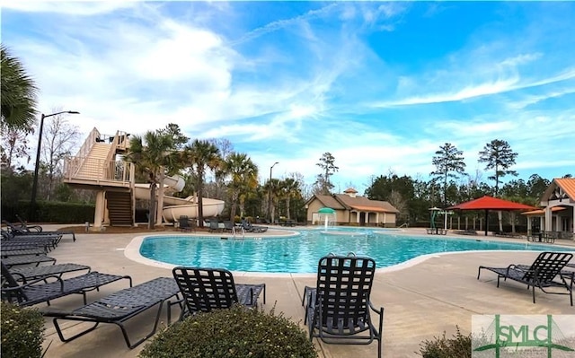 community pool featuring stairway and a patio area