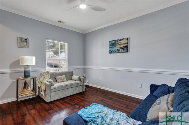 living area featuring wood finished floors, baseboards, visible vents, ornamental molding, and ceiling fan