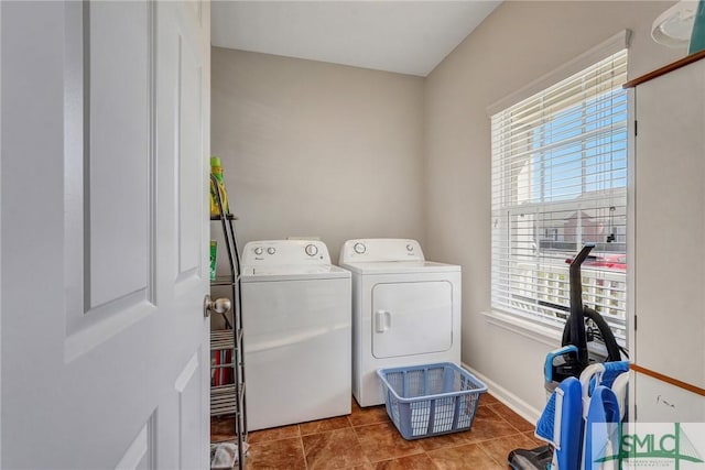 laundry room featuring tile patterned floors, laundry area, washing machine and dryer, and baseboards