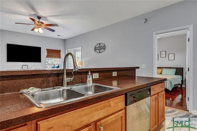 kitchen with dark countertops, dishwasher, a ceiling fan, and a sink