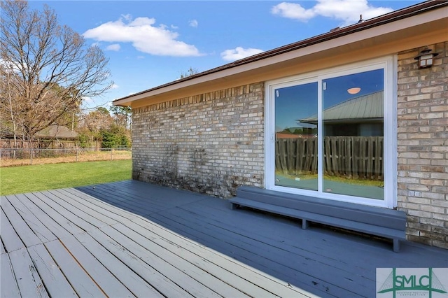 wooden deck featuring fence and a lawn