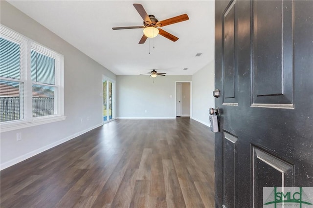 interior space featuring baseboards, ceiling fan, and dark wood-style flooring