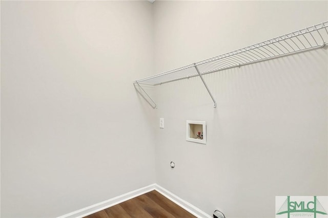 washroom with washer hookup, laundry area, baseboards, and dark wood-type flooring