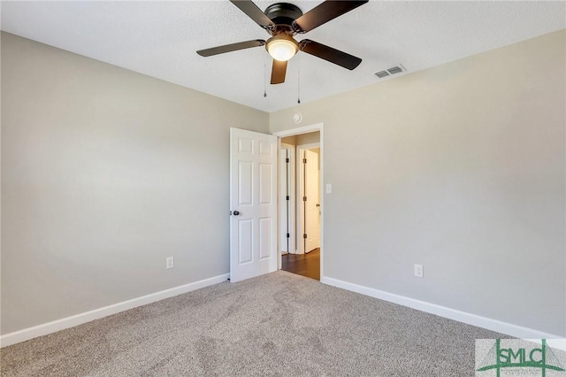 carpeted empty room featuring a ceiling fan, baseboards, and visible vents