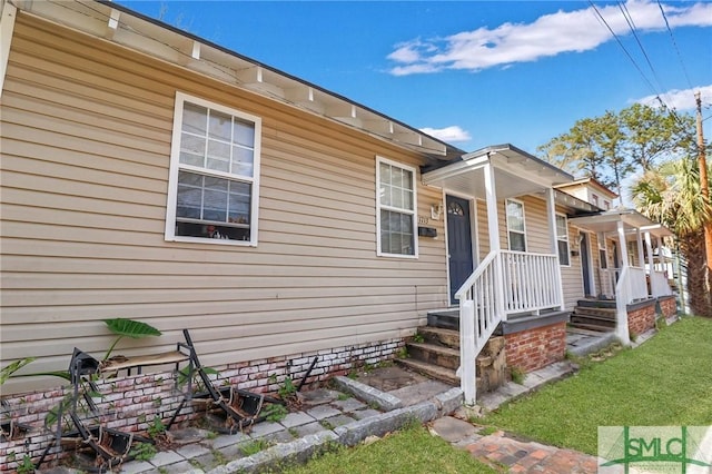 exterior space featuring covered porch and a front yard