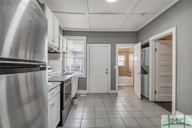 kitchen with appliances with stainless steel finishes, white cabinets, and a healthy amount of sunlight