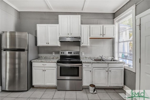 kitchen featuring light tile patterned floors, a sink, white cabinets, under cabinet range hood, and appliances with stainless steel finishes