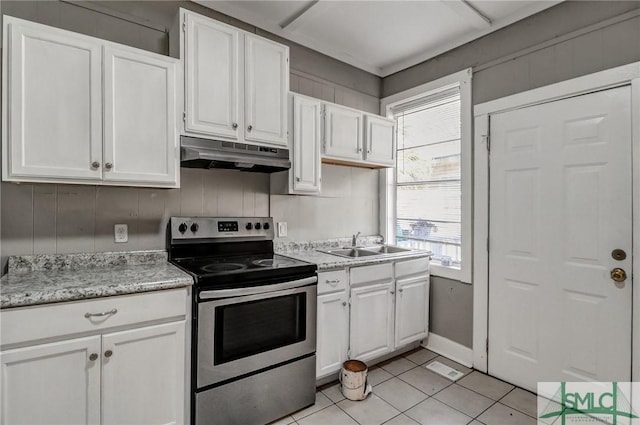 kitchen featuring under cabinet range hood, light tile patterned floors, white cabinets, and stainless steel range with electric cooktop