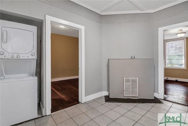 washroom featuring laundry area, light tile patterned floors, visible vents, and stacked washing maching and dryer