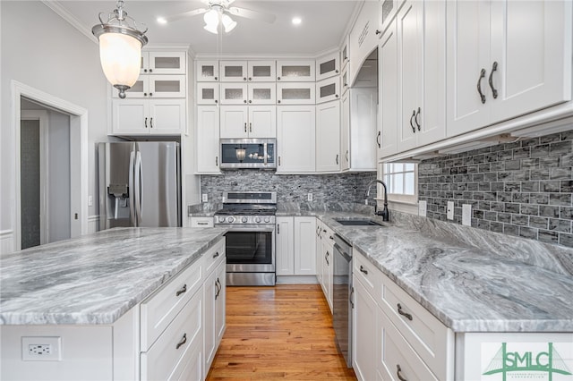 kitchen featuring ceiling fan, stainless steel appliances, light wood-style floors, white cabinetry, and a sink