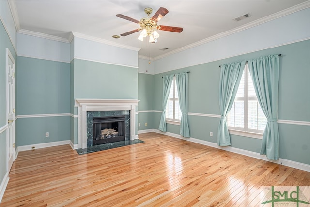 unfurnished living room with visible vents, wood-type flooring, a fireplace, baseboards, and ceiling fan