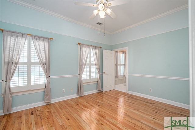 unfurnished room with hardwood / wood-style floors, ornamental molding, baseboards, and ceiling fan