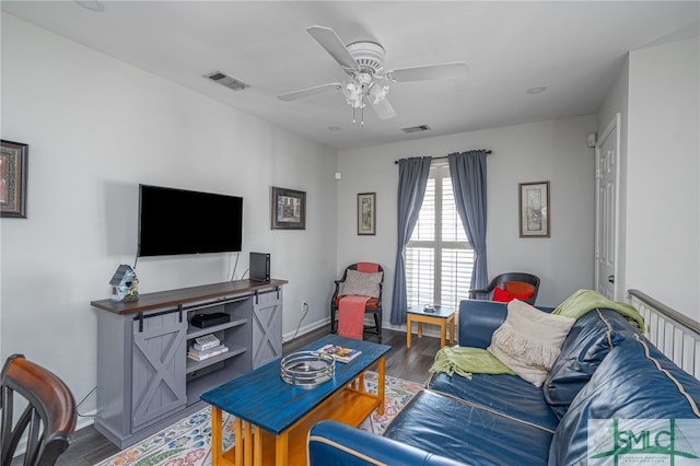 living room with visible vents, baseboards, wood finished floors, and a ceiling fan