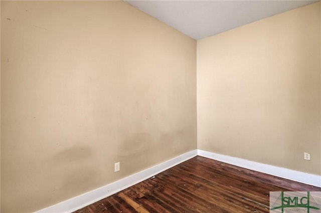 unfurnished room with dark wood finished floors and baseboards