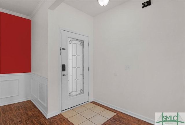 entryway featuring wainscoting, light wood-style flooring, and ornamental molding