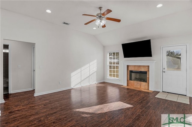 unfurnished living room featuring vaulted ceiling, a healthy amount of sunlight, a ceiling fan, and wood finished floors