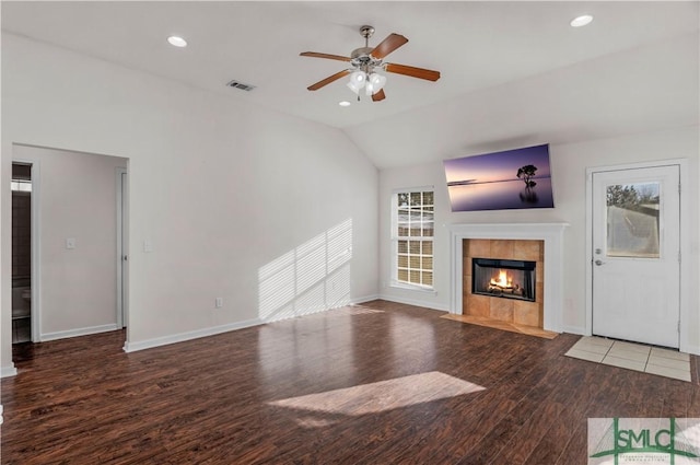 unfurnished living room with a tiled fireplace, wood finished floors, recessed lighting, ceiling fan, and vaulted ceiling