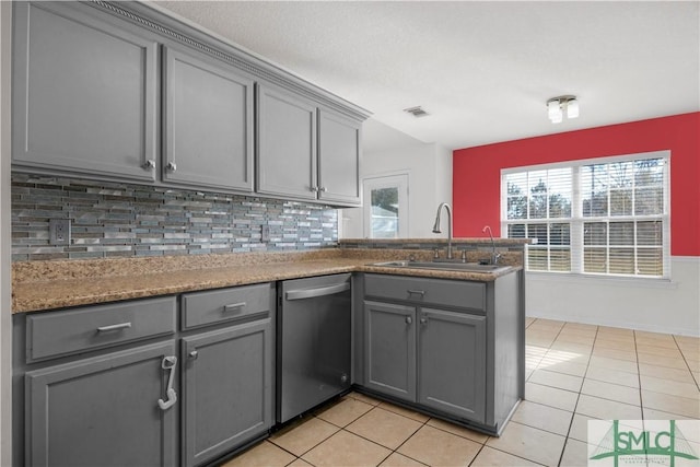 kitchen with a sink, gray cabinets, a peninsula, and stainless steel dishwasher