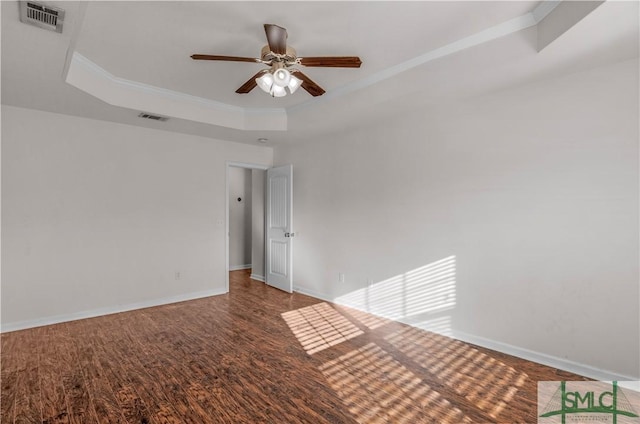 empty room with a raised ceiling, baseboards, and visible vents