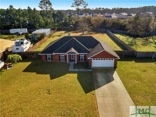 view of front facade featuring a front lawn, driveway, fence, a garage, and brick siding