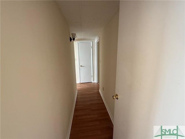 corridor featuring dark wood-style floors and baseboards