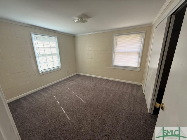 unfurnished bedroom featuring concrete block wall, ornamental molding, and carpet flooring